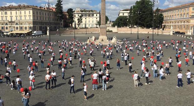 Roma, palloncini rossi e (vero) distanziamento: il flash mob degli infermieri a piazza del Popolo. «Un giorno ci corteggiano e quello dopo ci disprezzano»