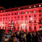 Femminicidi, 104 donne uccise nel 2022: Palazzo Chigi si illumina di rosso, proiettati i nomi delle vittime