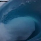 Decine di surfisti tentano di cavalcare un'onda gigantesca a Tahiti